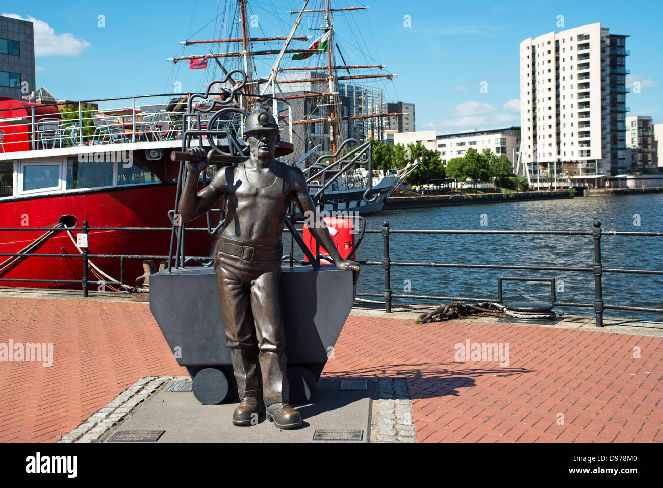 Statue d'un mineur de charbon dans la baie de Cardiff, en face du bateau-phare, sculptée par le sculpteur Gallois Robert Thomas, en bronze. Banque D'Images