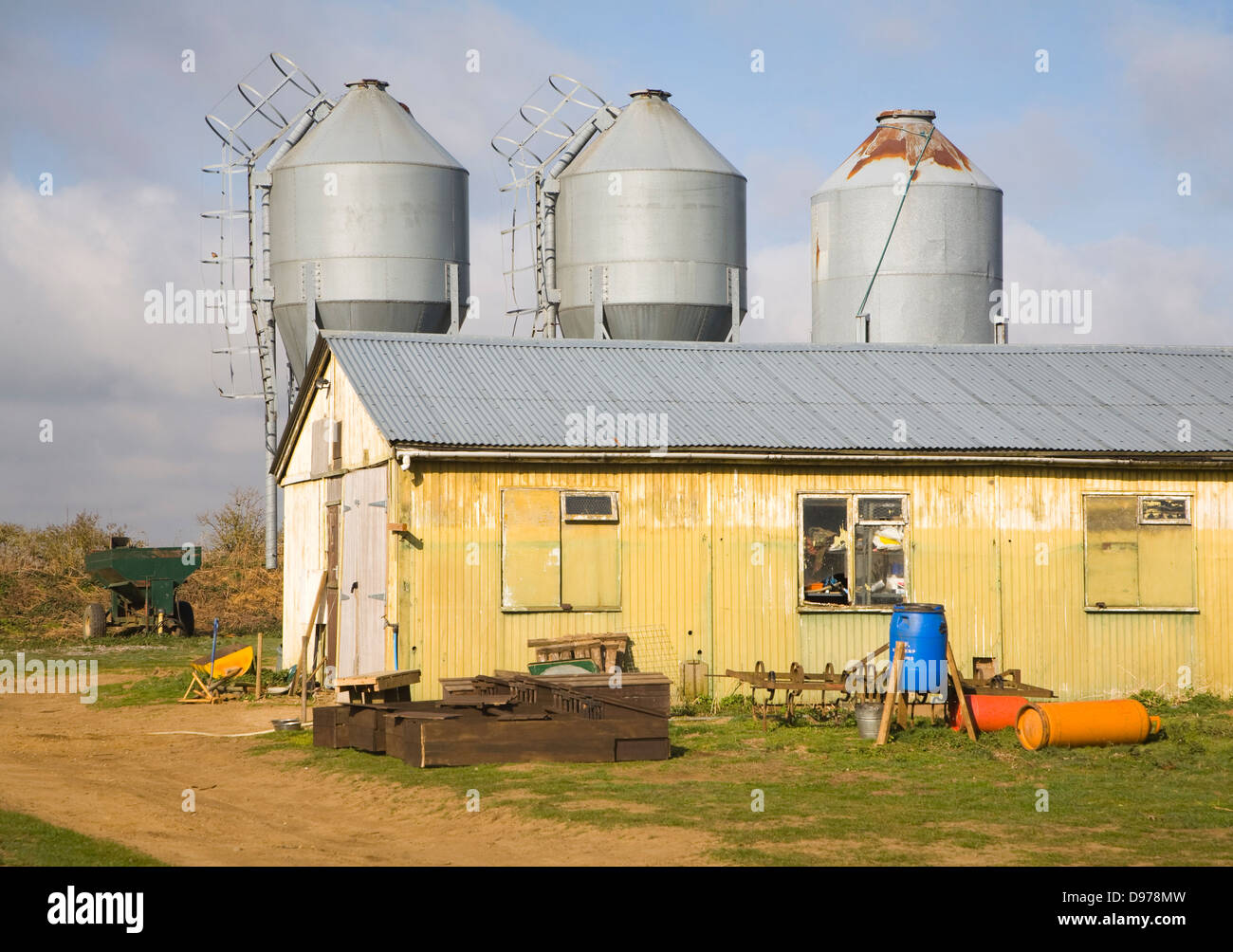 Trois silos de stockage d'alimentation en métal et grange en basse-cour, Alderton, Suffolk, Angleterre Banque D'Images