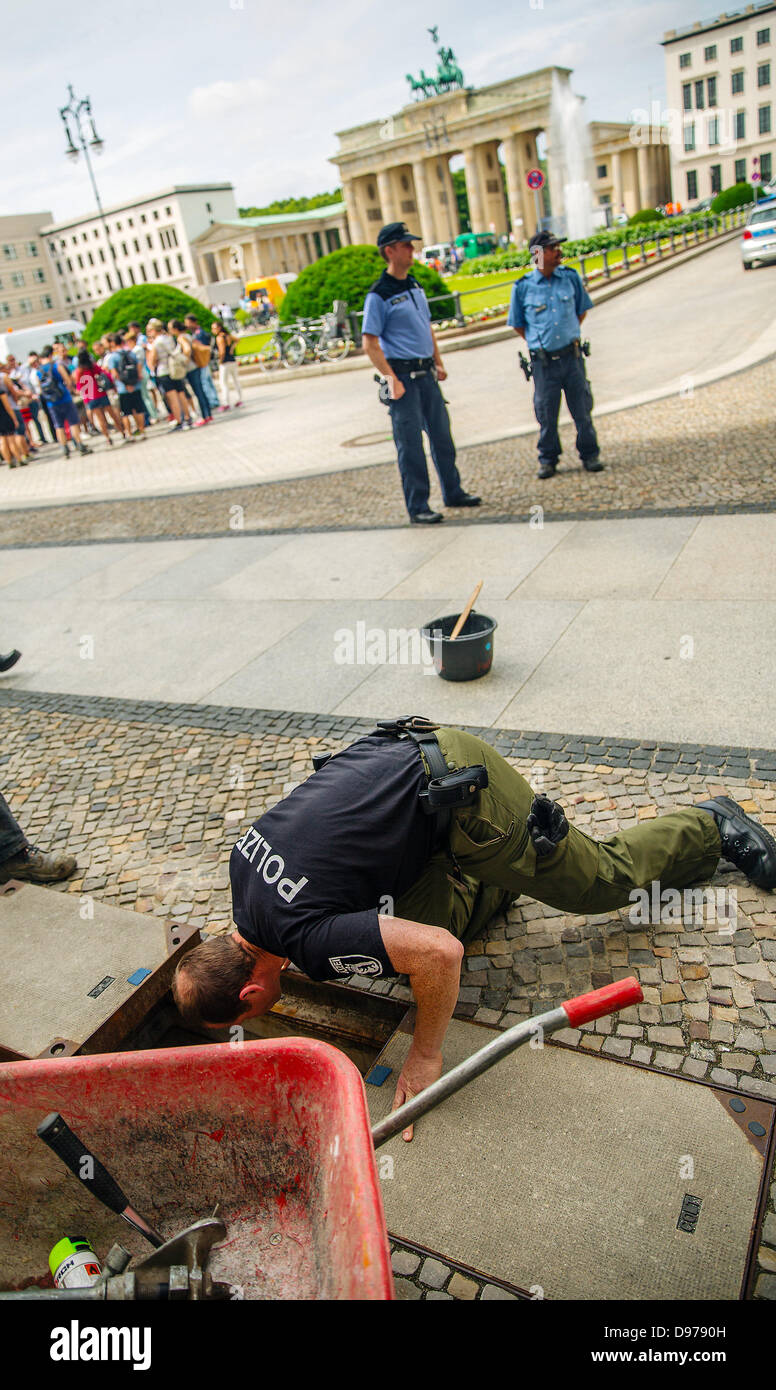 Berlin, Allemagne, 13 juin 2013. Les agents de police et les travailleurs d'un joint de couvercle d'égout à la porte de Brandebourg à Berlin, Allemagne, 13 juin 2013. Le président américain Barack Obama Berlin visites les 18 et 19 juin 2013. Le plus haut niveau de sécurité a été declarated dans la ville et centre de la ville sont fermées pendant la visite. Photo : Crédit photo : dpa HANNIBAL alliance/Alamy Live News Banque D'Images