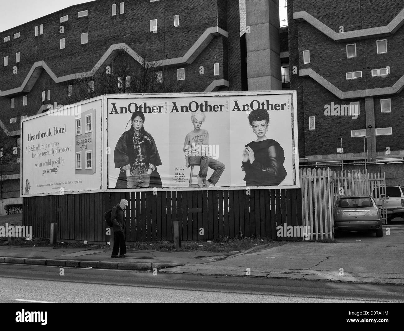 Homme marchant passé thésaurisation publicité sur Coldharbor Lane, Brixton en 1981. Dans l'arrière-plan est la nouvelle Maison Southwyck Banque D'Images