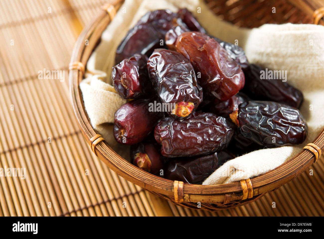 Fruits secs date palm ou kurma, ramadan food qui mangé dans mois de jeûne. Pile de fruits frais ou secs date en panier de bambou. Banque D'Images
