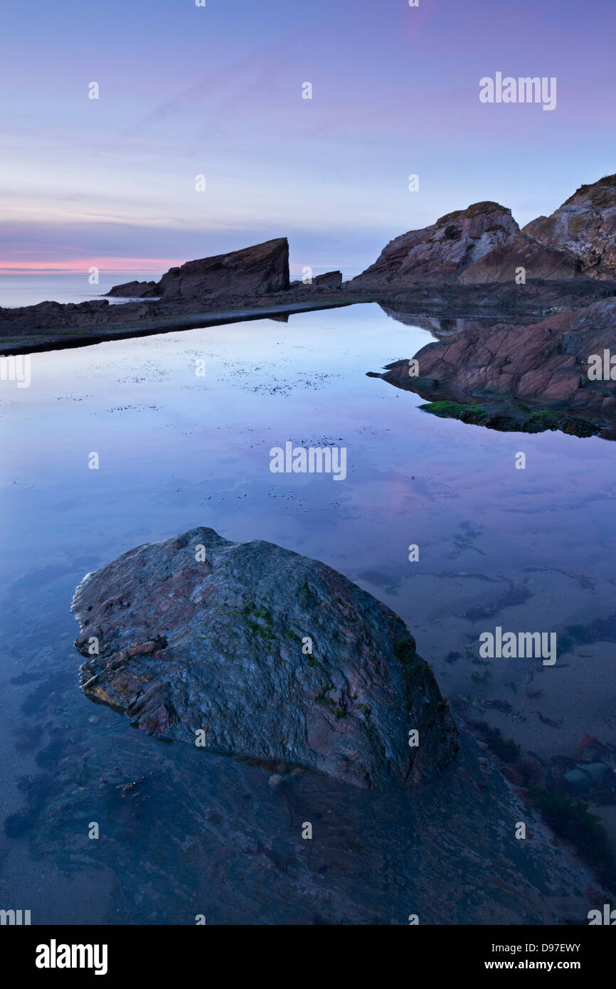 Le crépuscule sur le rivage rocheux de Combe Martin, Exmoor, Devon, Angleterre. Banque D'Images