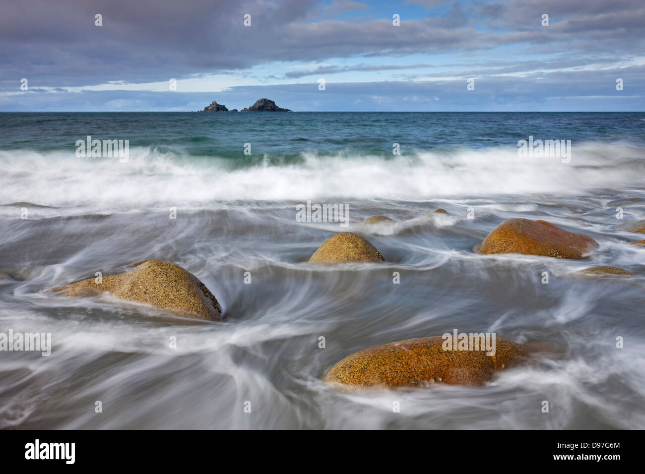 Vagues tourbillonnent autour des rochers sur la plage de Porth Nanven, Cornwall, Angleterre. Banque D'Images