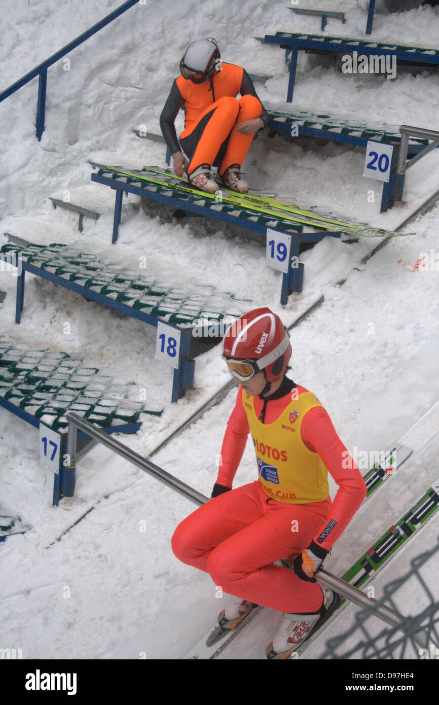 En haut de ski jump prépare à mettre en disponibilité. Un autre jumper attend et ajuste les bottes. Banque D'Images