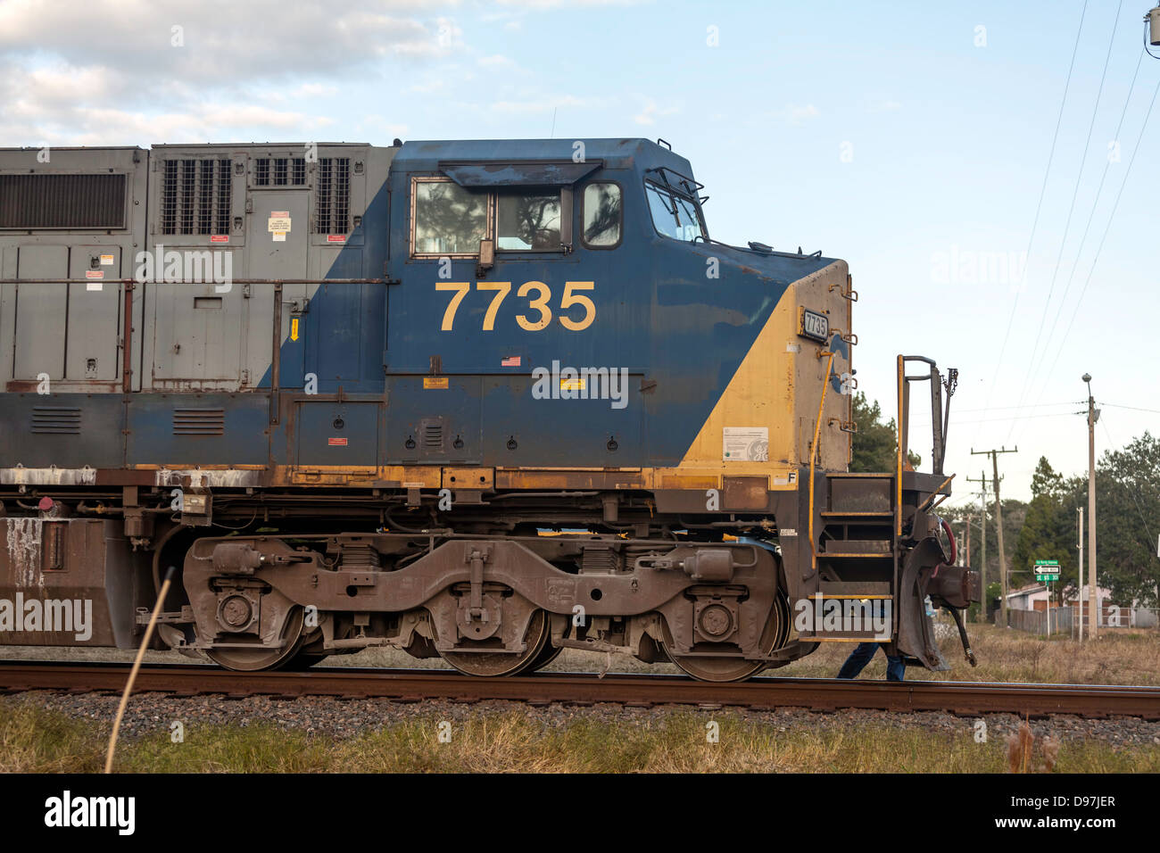 CSX 7735 moteur de traction d'un train de fret grâce à un passage à niveau à Hawthorne, en Floride. Le signaleur fonctionne à côté du moteur. Banque D'Images