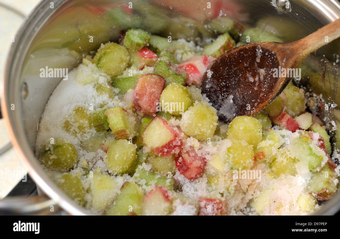 Les ingrédients dans une casserole pour faire de la confiture de rhubarbe et de groseilles. Banque D'Images