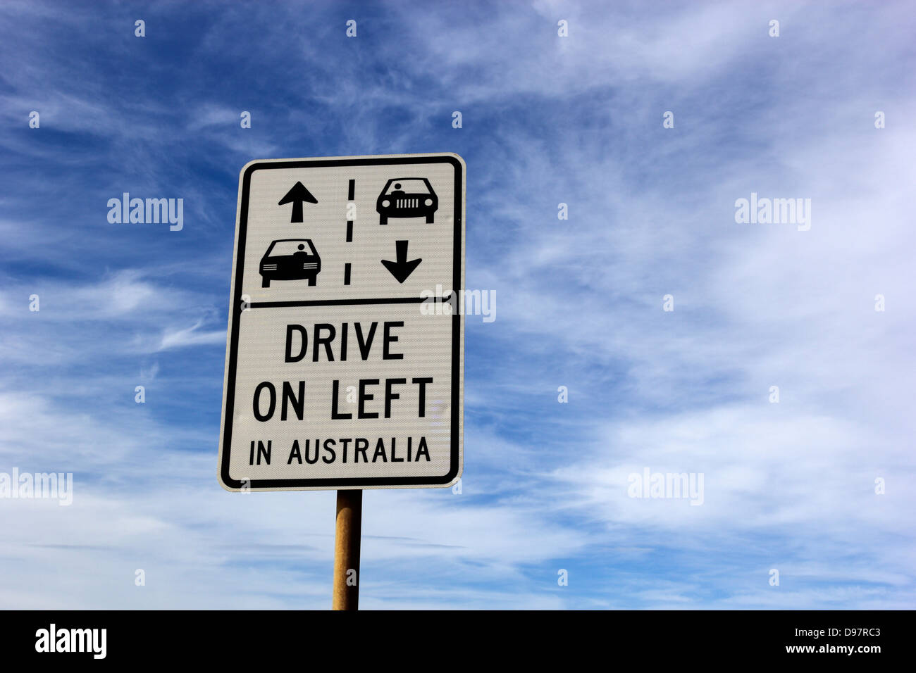Conduire à gauche en Australie sign vu contre ciel nuageux Banque D'Images