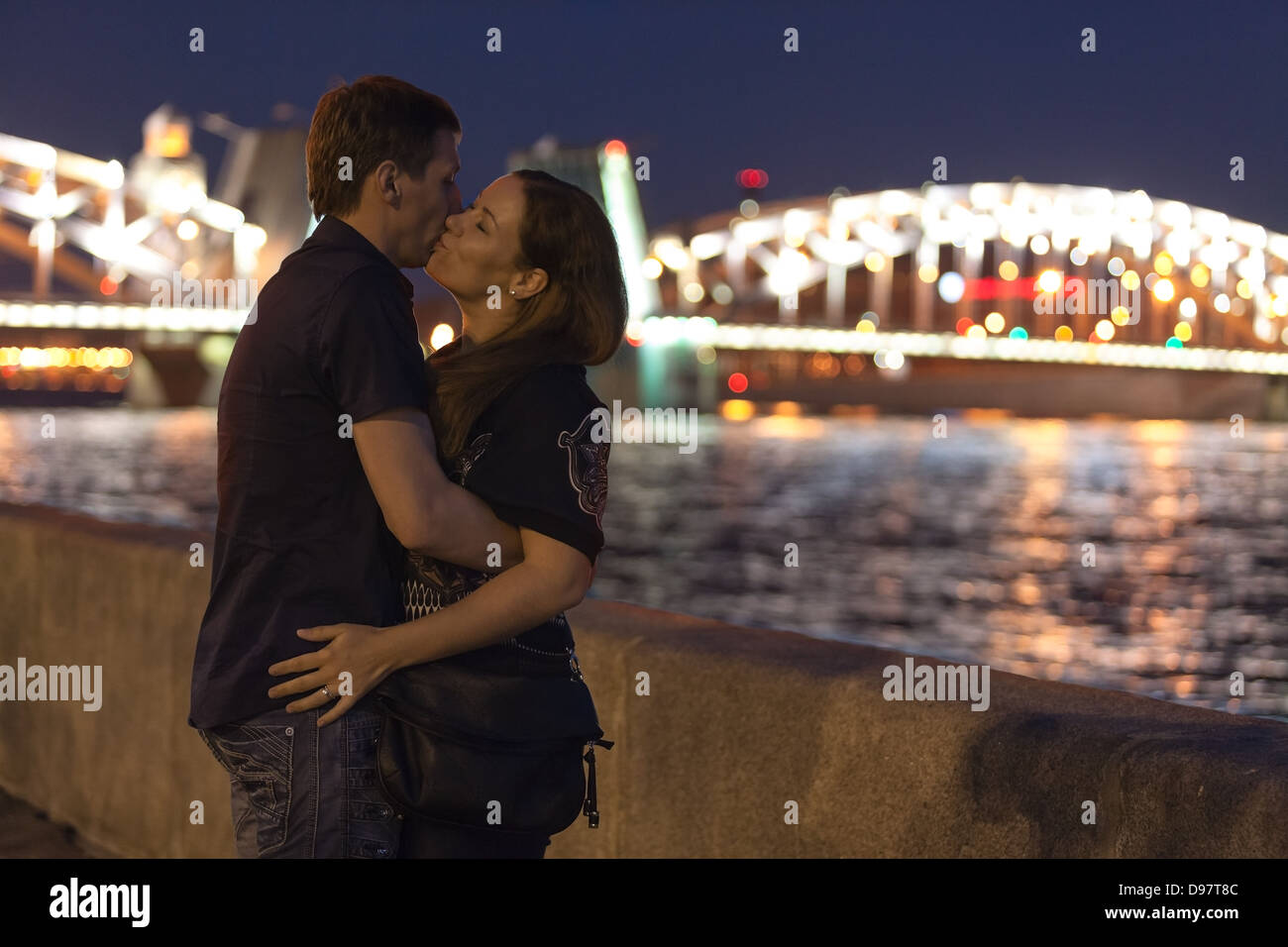 Aimer Caucasian couple kissing sur un remblai de granit en face du pont Bolsheokhtinsky à Saint-Pétersbourg. Période de nuits blanches Banque D'Images