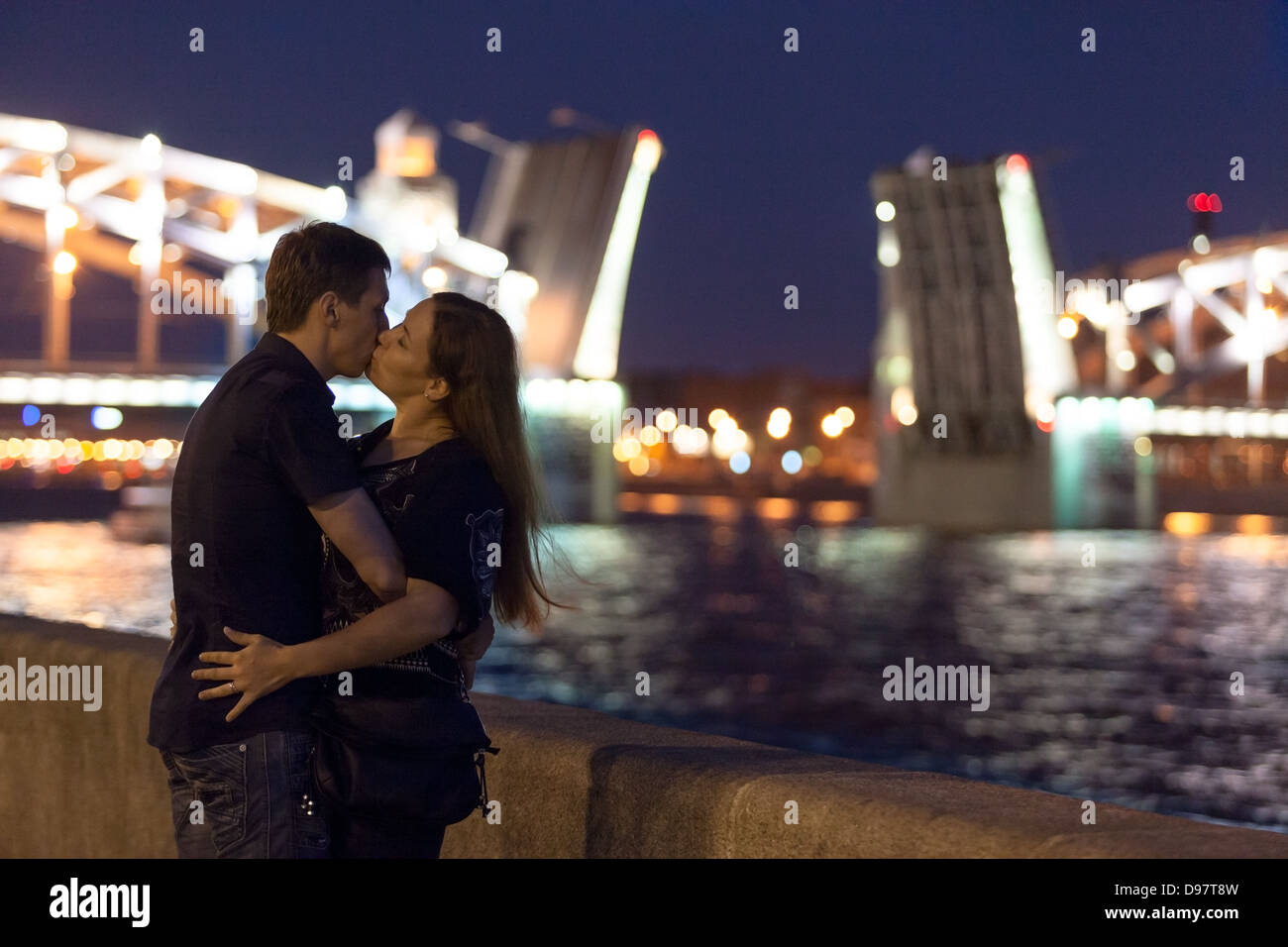 Couple aimant s'embrasser sur un remblai de granit en face du pont Bolsheokhtinsky à Saint-Pétersbourg. Période de nuits blanches en Russie Banque D'Images