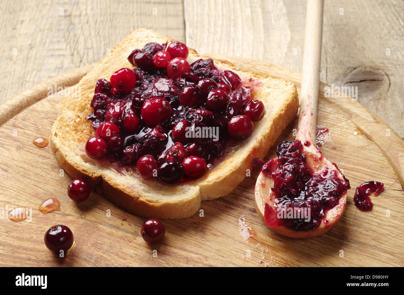 Toast avec confiture de canneberges sur une planche à découper Banque D'Images