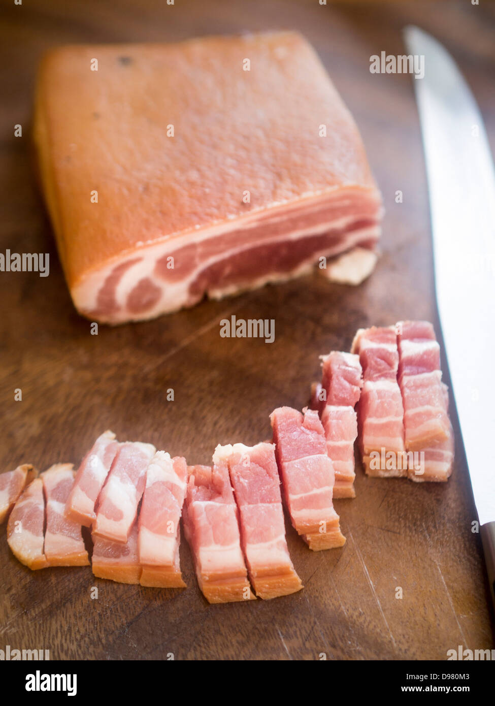 Ensemble de produits artisanaux, lard fumé en lardons coupés en partie Banque D'Images