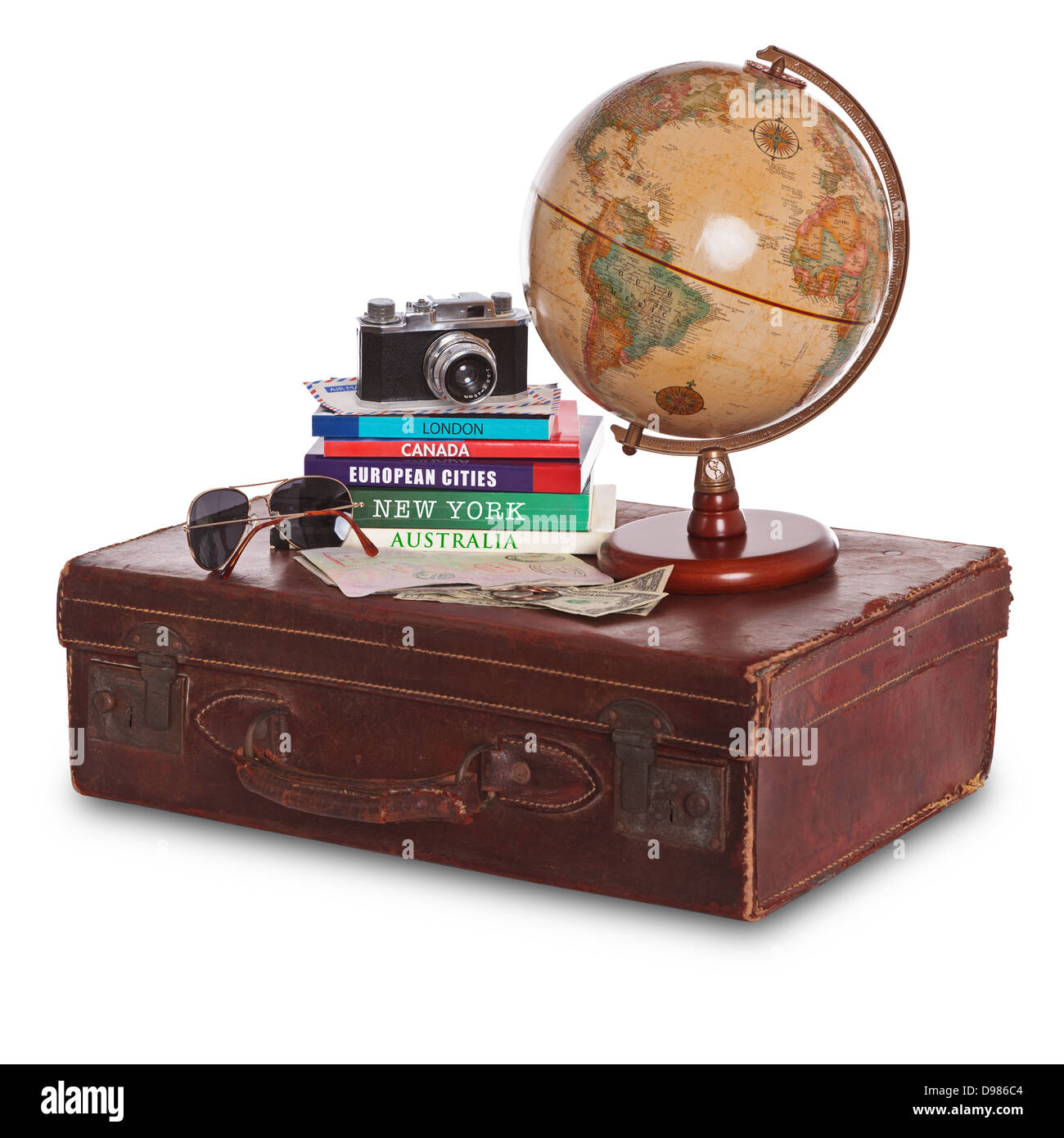 La nature morte photo d'une vieille valise en cuir brun avec un appareil photo, guides de voyage, globe terrestre, lunettes de soleil, passeport estampillé et paiement Banque D'Images