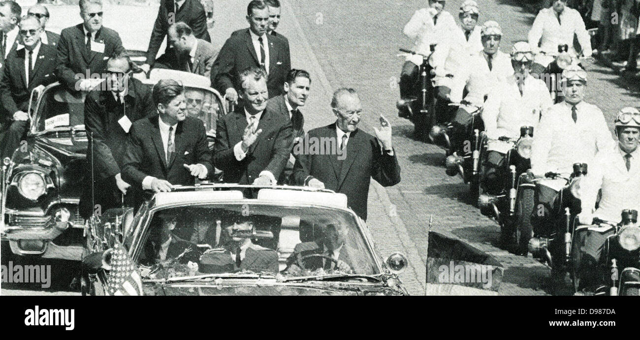 John F Kennedy (1917-1963) Président de l'USA, Willy Brandt (1913-1992) et Konrad Adenauer (1876-1967), Chancelier de l'Allemagne de l'Ouest voyageant à Berlin dans une voiture ouverte et reconnaissant la foule lors d encouragements de la visite du Président de la République fédérale d'Allemagne, 26 juin 1963. Banque D'Images