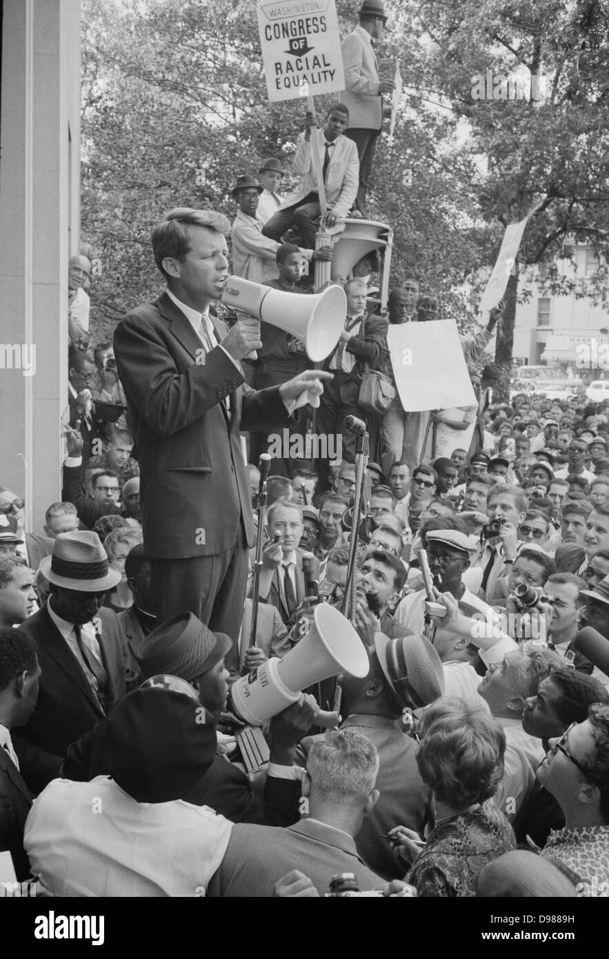 Photo montrant le procureur général Robert F Kennedy s'adressant à une foule des Afro-Américains et les blancs à travers un mégaphone à l'extérieur du Ministère de la Justice ; connectez-vous pour le congrès de l'égalité raciale est affiché bien en vue. 14 juin 1963. Photographe : Warren K Leffler. Banque D'Images