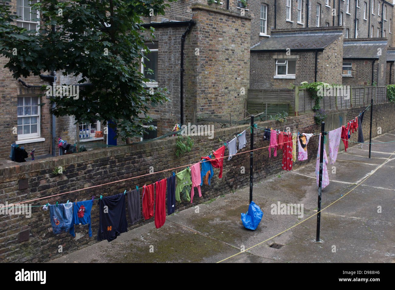 Laver les vêtements accrochés sur une ligne dans un lotissement de Pimlico, à Londres. Ce qui reflète une époque révolue où les résidents d'immeubles du centre-ville et des quartiers d'habitations accrochées à leur lavage Lavage sur jours (habituellement du lundi au Royaume-Uni), s'appuyant sur l'honnêteté et l'esprit communautaire pour assurer leur sécurité. Nous voyons aujourd'hui c'est rarement en dehors des cours comme celui-ci dans l'ouest de Londres. Les murs sont en briques fromclassic bourse de Londres mais les couleurs d'un secteur dynamique de la Grande-Bretagne du 21e siècle sont vus enfilés le long de la ligne. Banque D'Images