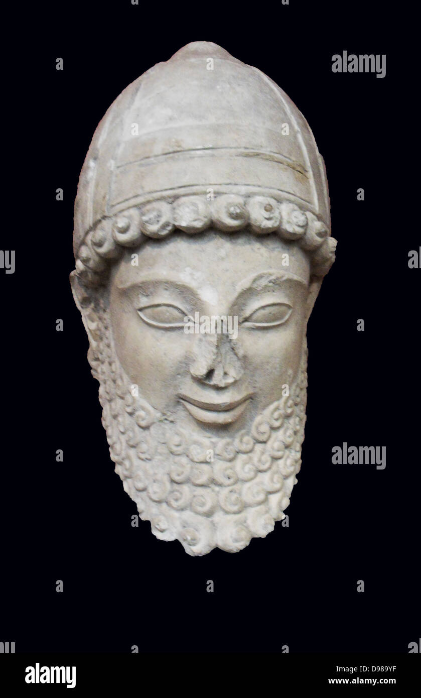 Tête en pierre calcaire de la statue d'un adorateur portant un casque avec le joue-pièces. Fait à Chypre, 525-500 BC. Fom le sanctuaire d'Apollon à Idalion. Banque D'Images