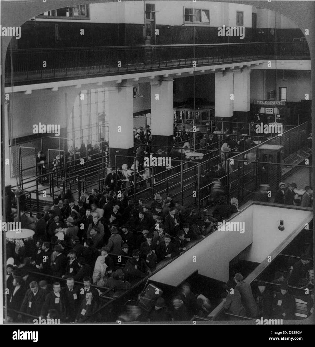 Les immigrants arrivés aux etats unis de l'Europe attendent d'être traitées dans le bâtiment d'immigrants, Ellis Island, New York. Banque D'Images