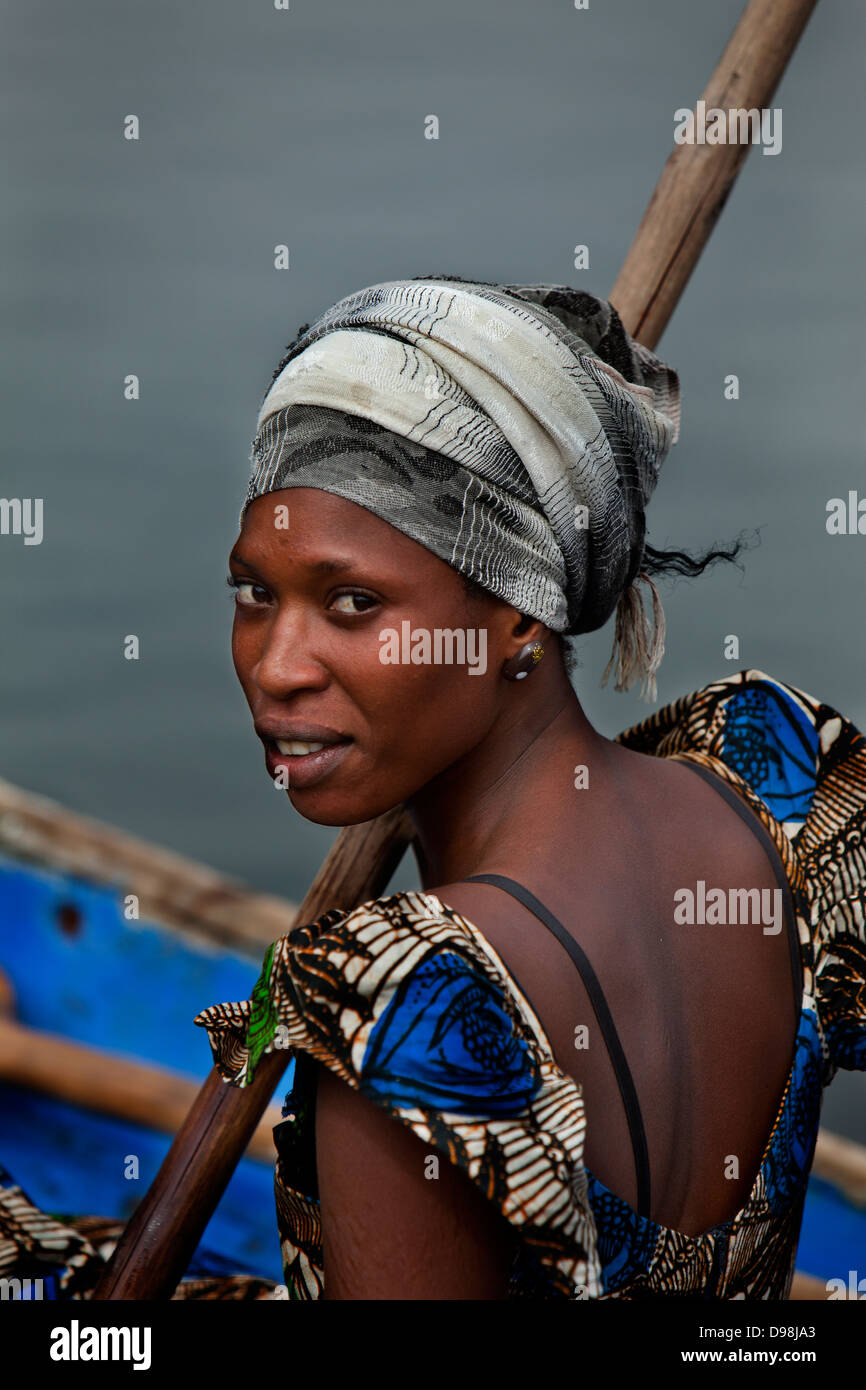 Une femme du village de Falia pirogue traditionnelle de l'aviron à travers les bolongs et les mangroves, Palmarin, Sénégal, Afrique Banque D'Images