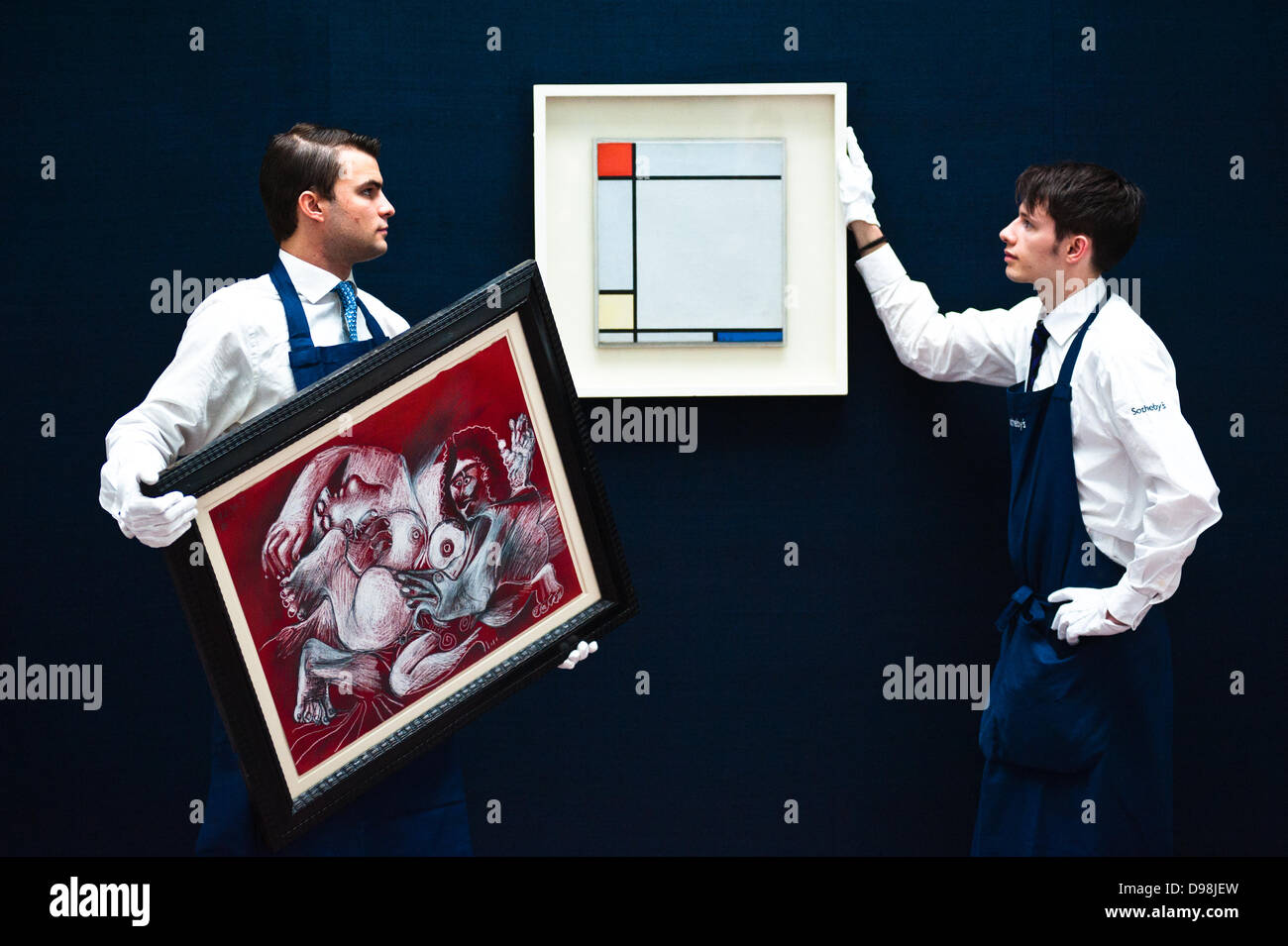 London,UK - 14 juin 2013 : Sotheby's employés apportent une œuvre de Piet Mondrian intitulé "Composition avec rouge, jaune et bleu, 1927) (est. £4,5 à 2,5 millions) (R) et "Etreinte" de Pablo Picasso (est. 1,5 à 2 millions de livres sterling (L) lors de l'aperçu de l'été vente aux enchères à Sotheby's. Credit : Piero Cruciatti/Alamy Live News Banque D'Images