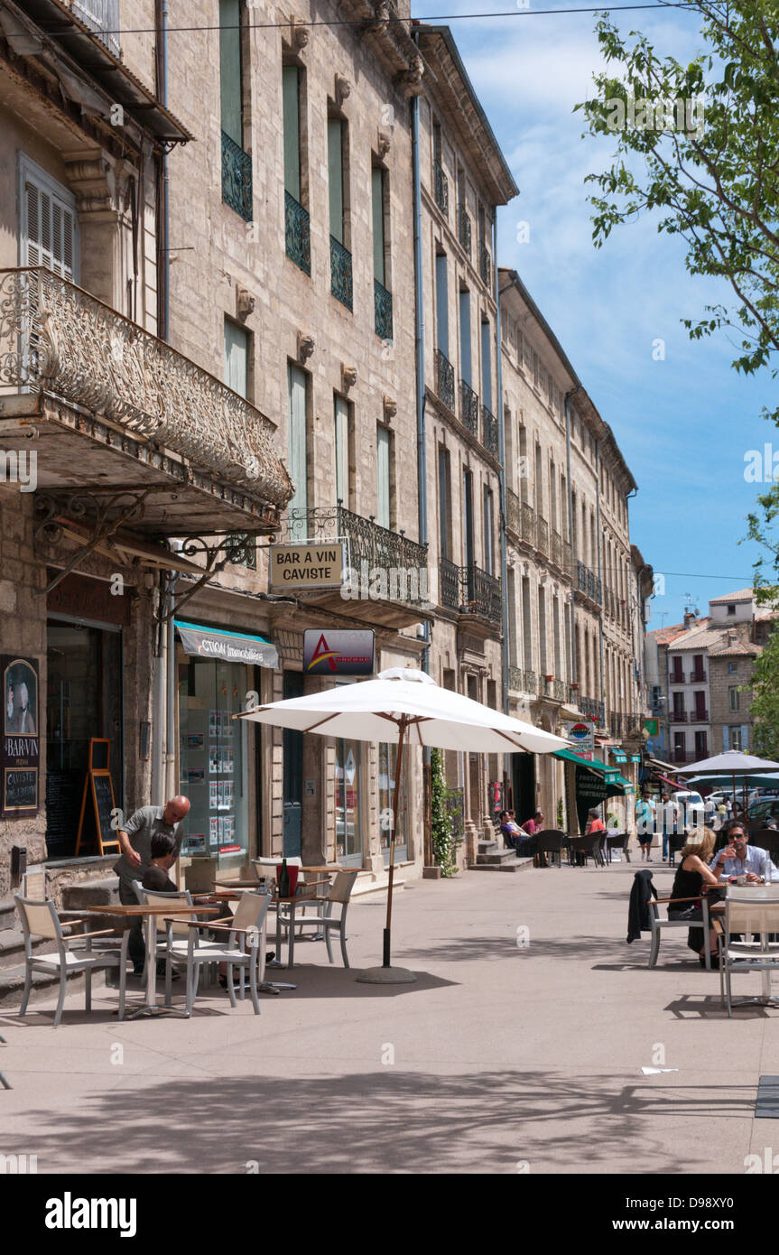 Les gens assis à l'extérieur d'un bar dans une rue élégante à Pézenas. Banque D'Images