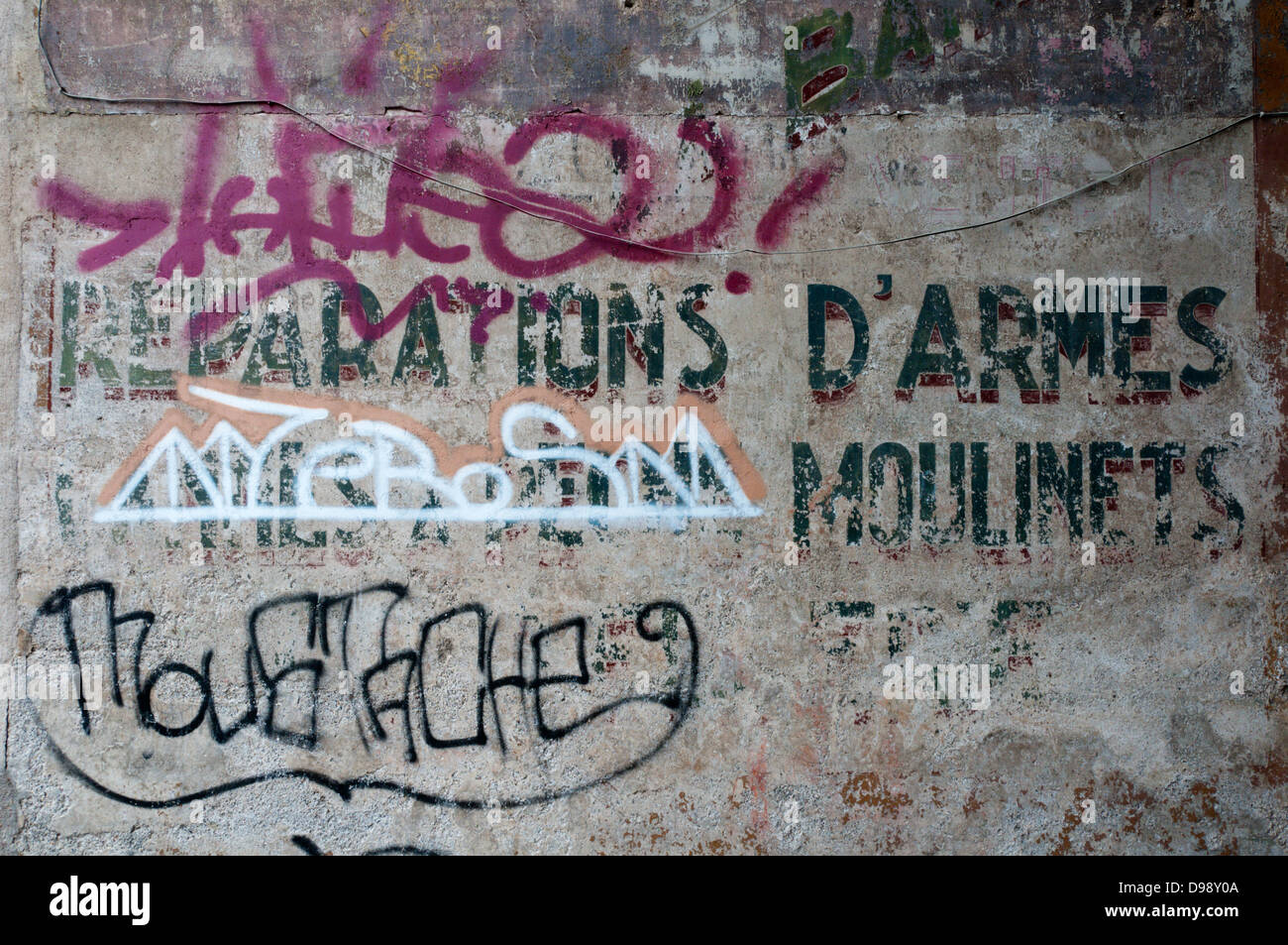 Graffiti moderne sur les vestiges d'une vieille enseigne publicitaire en France. Banque D'Images
