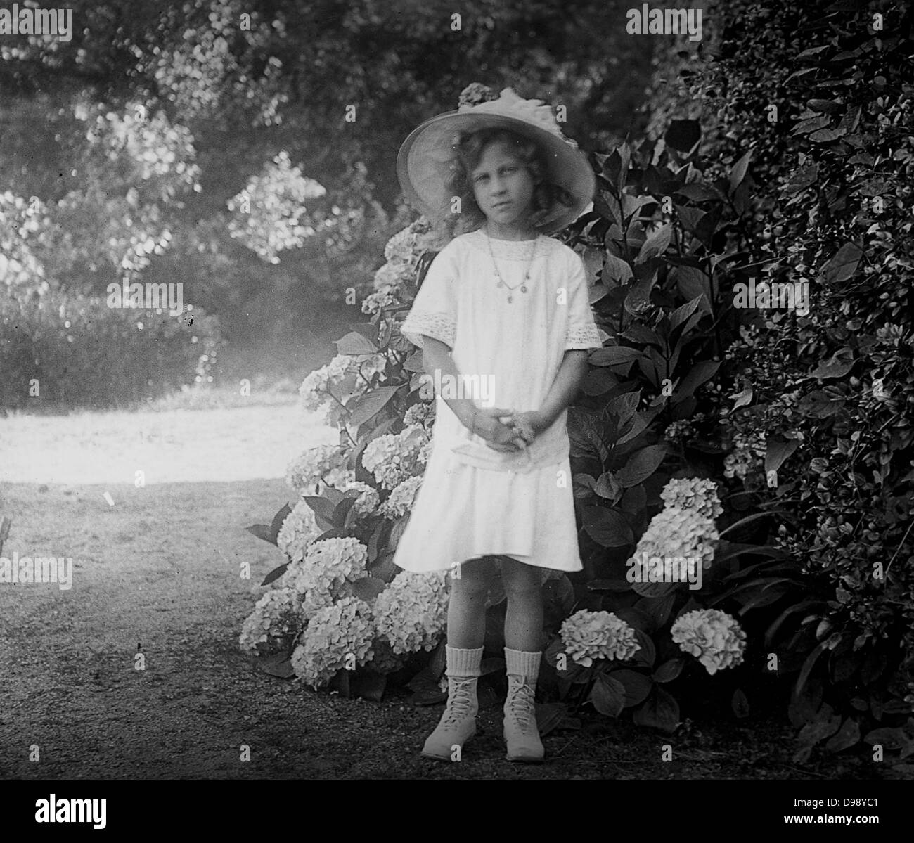 Jeune fille française dans un jardin. Vers 1900 Banque D'Images