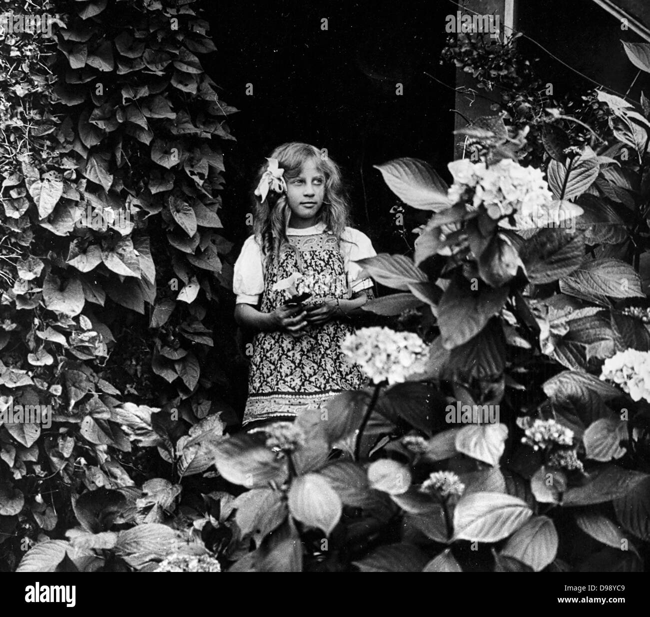 Jeune fille française dans un jardin. Vers 1900 Banque D'Images