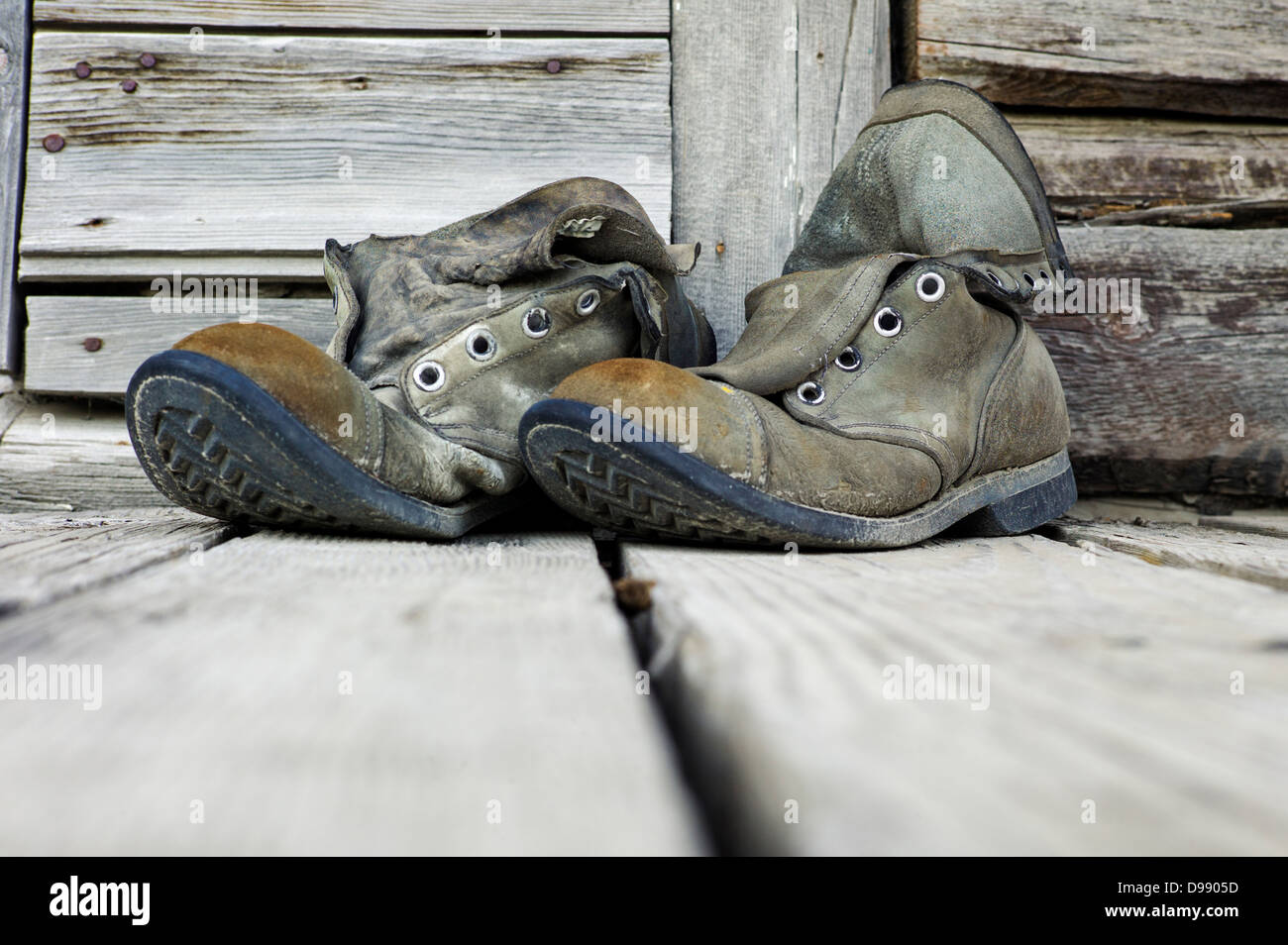 Old weathered chaussures de randonnée sur le porche en bois de l'Emporium Chitina, minuscule et la ville éloignée de Chitina, Alaska, USA Banque D'Images