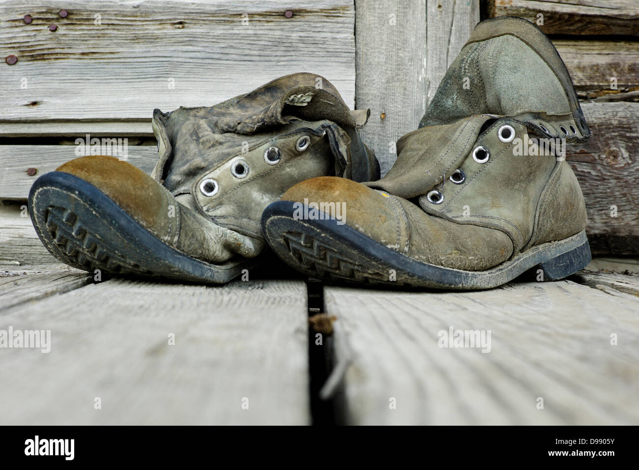 Old weathered chaussures de randonnée sur le porche en bois de l'Emporium Chitina, minuscule et la ville éloignée de Chitina, Alaska, USA Banque D'Images