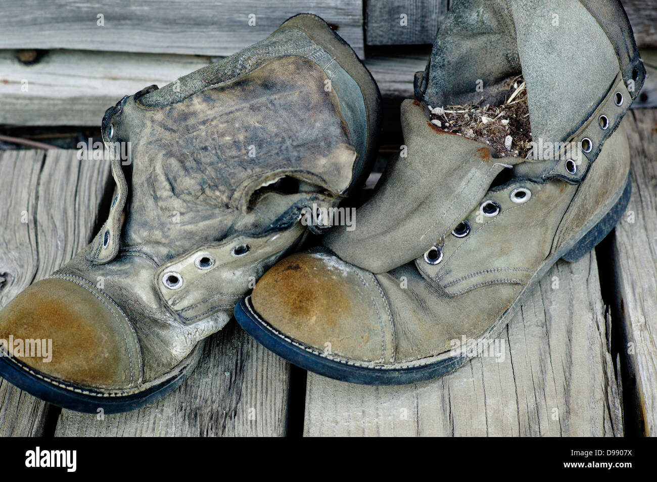 Old weathered chaussures de randonnée sur le porche en bois de l'Emporium Chitina, minuscule et la ville éloignée de Chitina, Alaska, USA Banque D'Images
