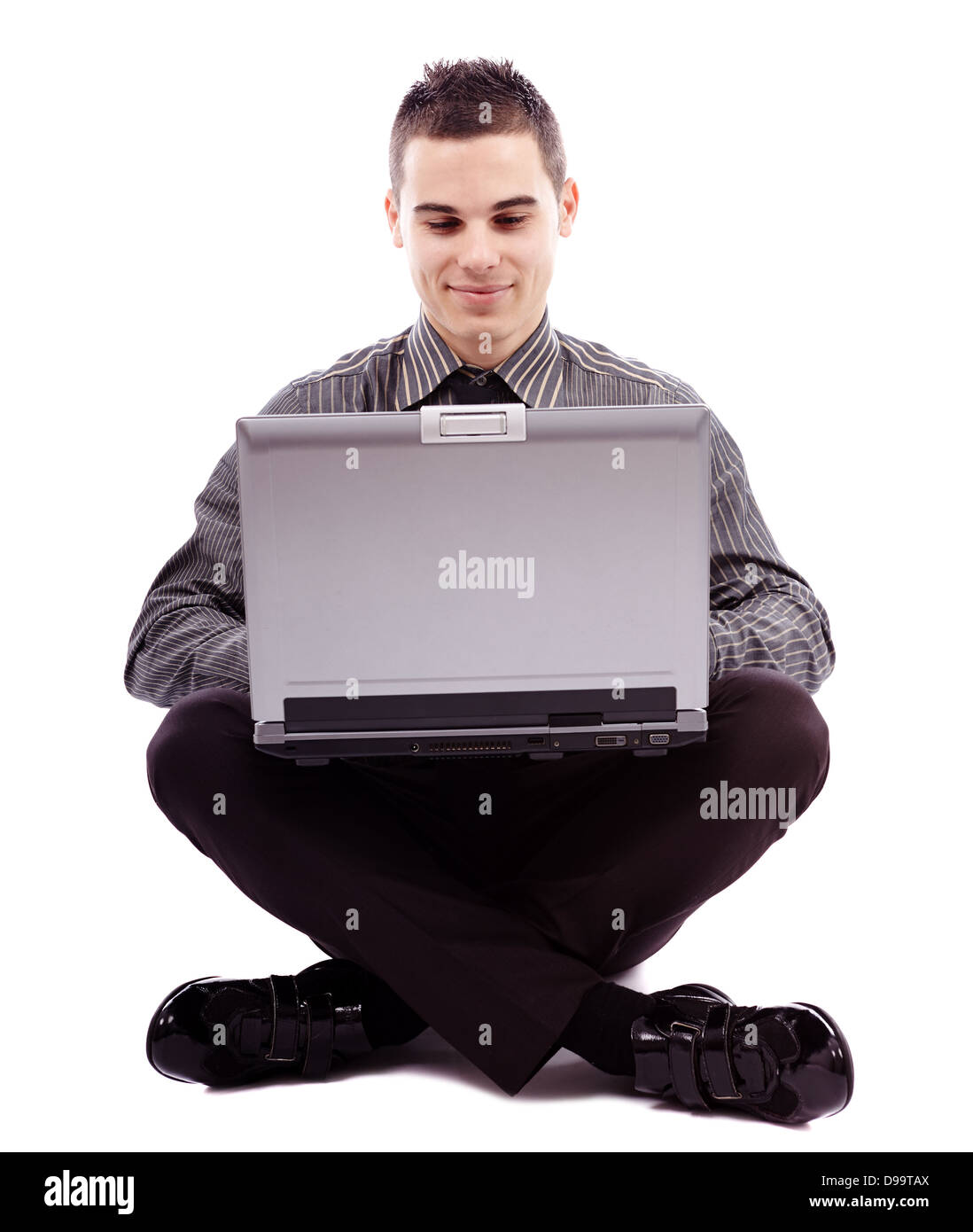 Longueur totale de pose assis sur le plancher et à écrire sur son ordinateur portable, isolé sur fond blanc Banque D'Images