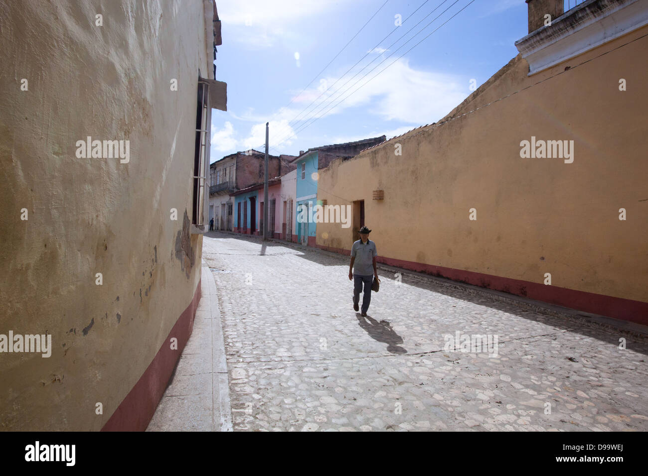 L'homme marchant dans une rue pavée de Trinidad, Cuba. Banque D'Images