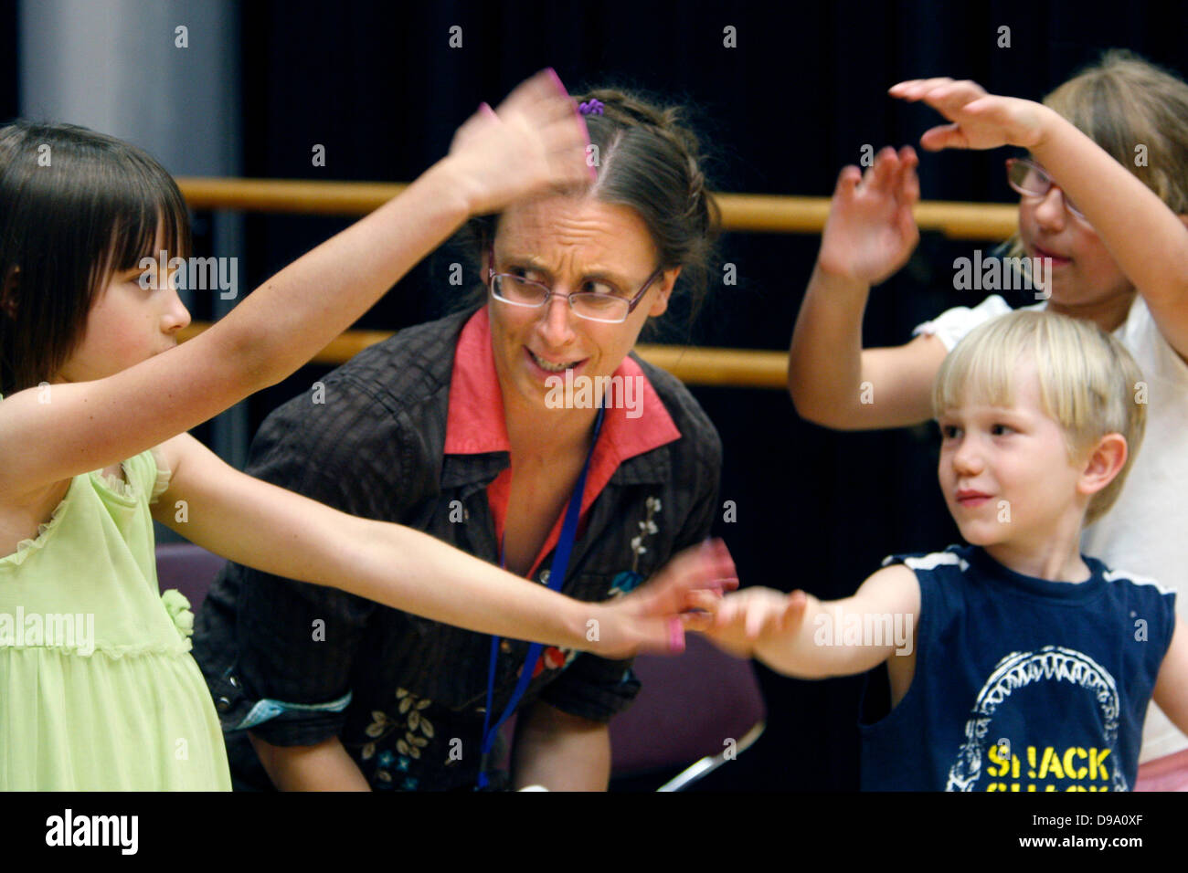 12 juin 2013 - Bartlett, New York, États-Unis - 12 juin 2013 - Tanya Instructeur Henderson explique comment réaliser viney armes aux enfants d'apprendre à être de petites fleurs. Les enfants ont pratiqué toute la semaine pour mettre sur une performance de The Secret Garden at Bartlett Performing Arts Center Missoula avec le théâtre pour enfants. 58 enfants ont appris un spectacle en cinq jours qui sera effectué pour le public dans deux spectacles le samedi à 2:30 et 7:30. Il s'agit d'un processus d'apprentissage des compétences tout au long de la vie à travers les arts et parfumant Kitty Walters, Droite, Michael James (2e à partir de la droite) et Emma Thorne sur la gauche. (Crédit I Banque D'Images