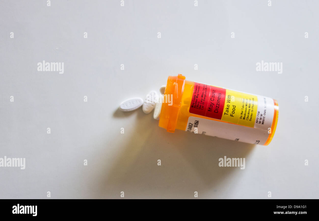 Une bouteille d'ordonnance couché sur le côté avec des comprimés. Arrière-plan blanc. USA. Banque D'Images