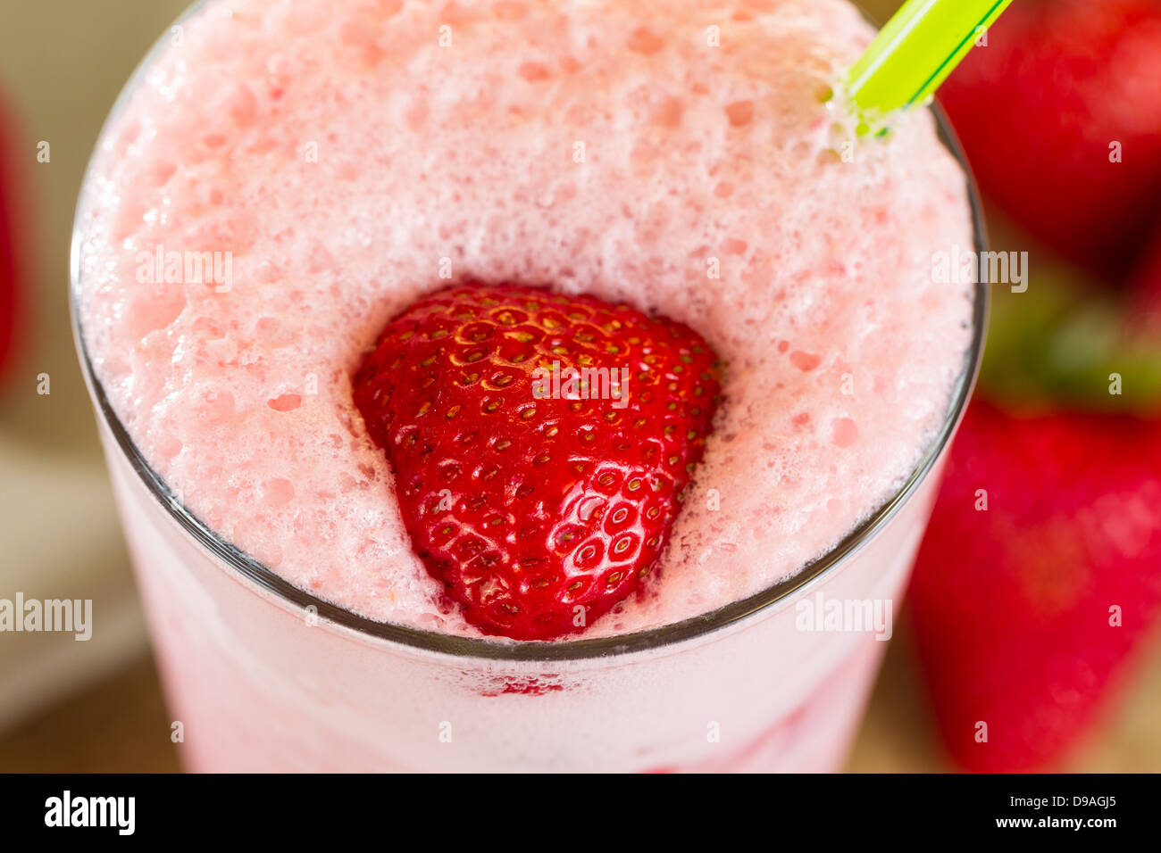 Voir photo macro horizontale de fraises fraîches, super milkshake crémeux, avec l'accent sur berry sur haut de shake Banque D'Images
