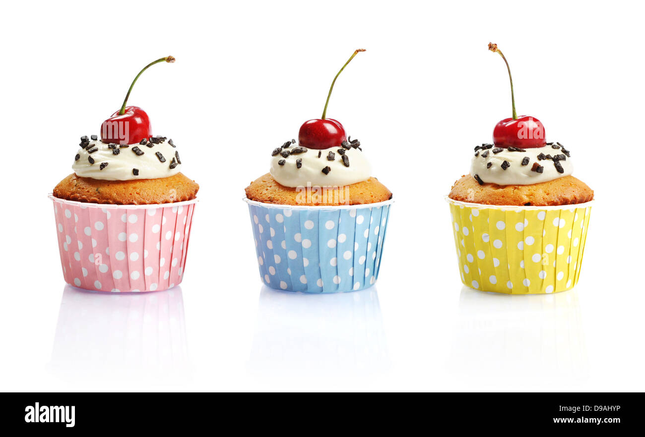 Cupcakes avec de la crème fouettée et de cerises isolé sur fond blanc Banque D'Images