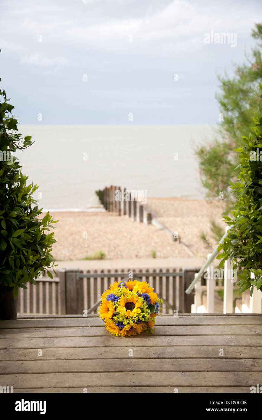 Bouquet de mariée avec des tournesols sur marches de bois de Beach House salle de mariage avec vue sur plage et mer en arrière-plan Banque D'Images