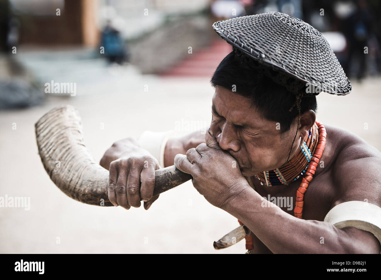 Tribu Naga soufflant cor de chasse au cours de l'assemblée statue d'Festival à Kisama, Kohima, Nagaland, Inde Banque D'Images