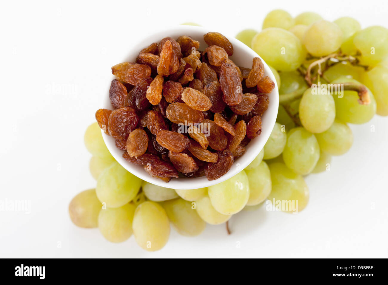 Bol de sultanines avec raisin vert sur fond blanc, Close up Banque D'Images