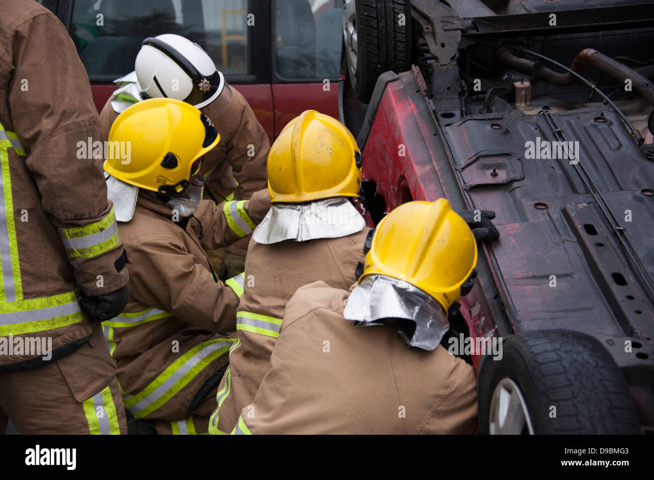 Panne de voiture pilote de sauvetage des pompiers à l'envers Banque D'Images