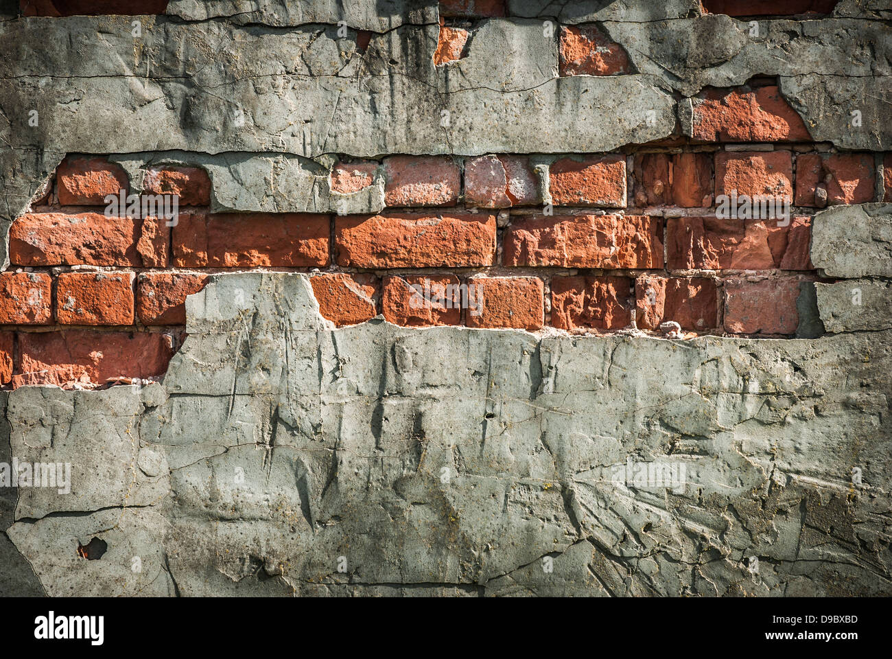 Un vieux mur de briques rouges en terre cuite érodé avec fond en plâtre cassé. Banque D'Images