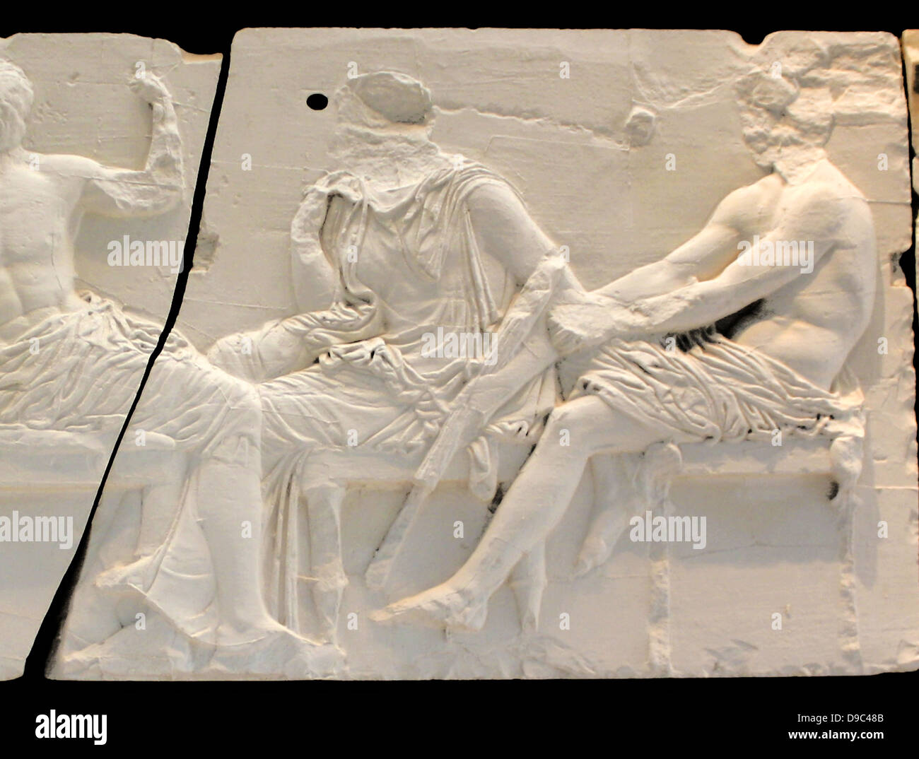 Quatre hommes (20-23) lean dans une ambiance fashion sur leurs bâtons en face de quatre divinités (24-27) assis sur des tabourets. Comme les deux hommes sur le bloc précédent III, ils sont habituellement identifiés comme le héros éponyme, fondateurs de la tribus grenier Banque D'Images