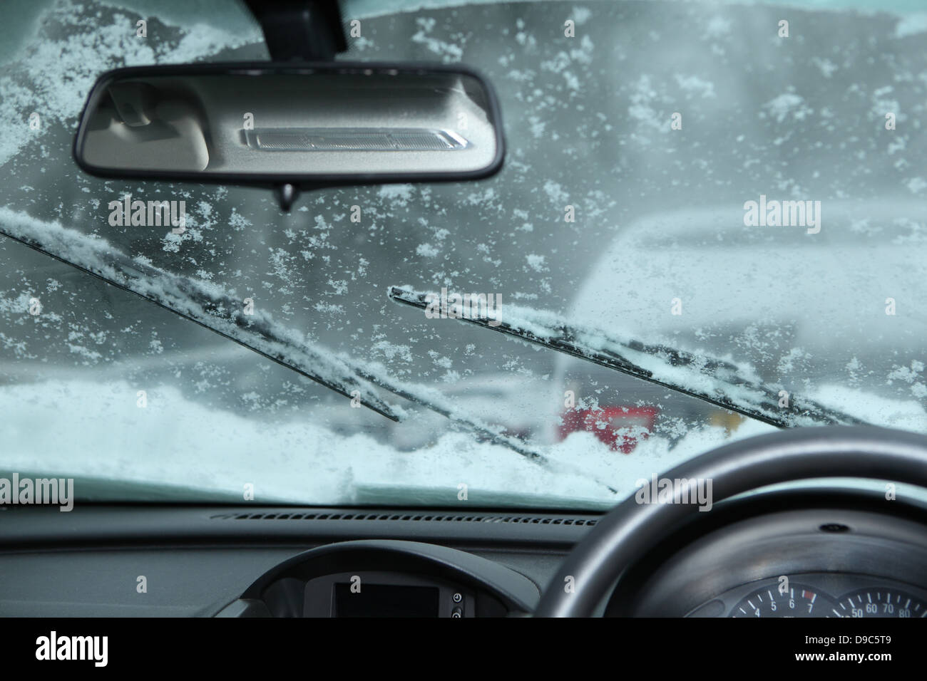 Rue couverte de neige vue à travers pare-brise de voiture Banque D'Images