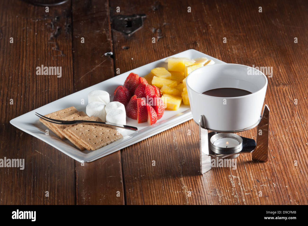 Bac de fondue fraises, ananas, les guimauves et biscuits graham avec du chocolat fondu pour une collation. Banque D'Images