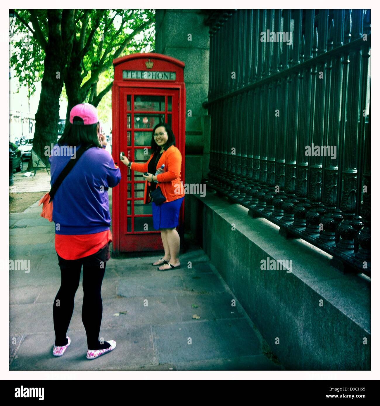 Juin 16, 2013 - Londres, Royaume-Uni - Des touristes prenez des photos d'eux-mêmes par le téléphone rouge traditionnelle britannique fort, situé près de la porte pour les Britanniques, Musée de Londres, Royaume-Uni. Photographié avec l'iphone, l'application hipstamatic. (Crédit Image : ©/ZUMAPRESS.com) Lukasova Veronika Banque D'Images