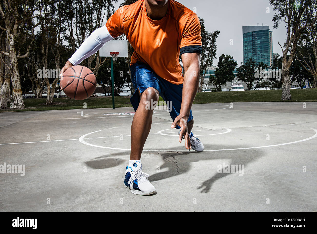 Jeune homme jouant au basket-ball sur cour, Close up Banque D'Images