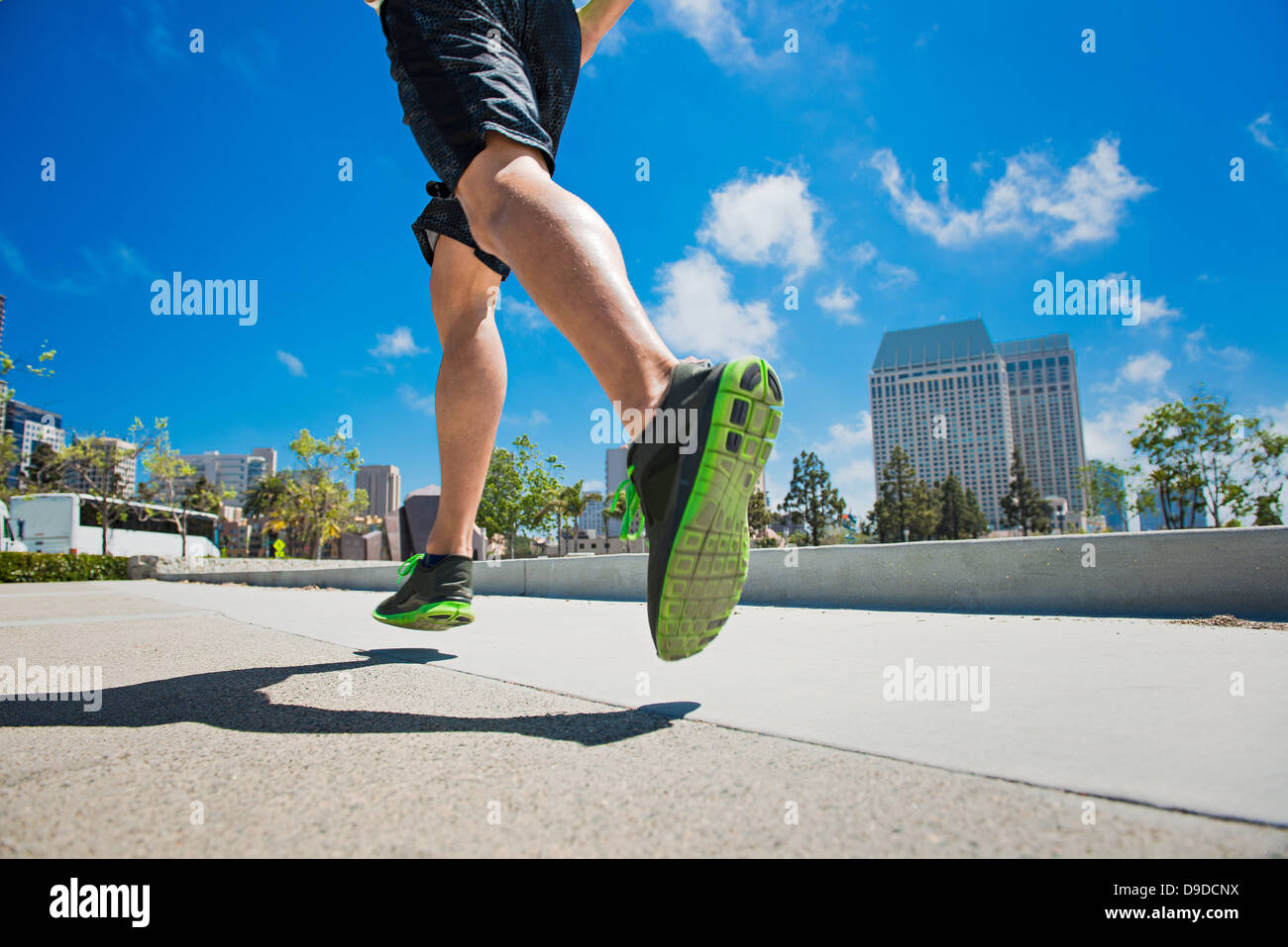 Jeune homme jogging en ville, low section Banque D'Images