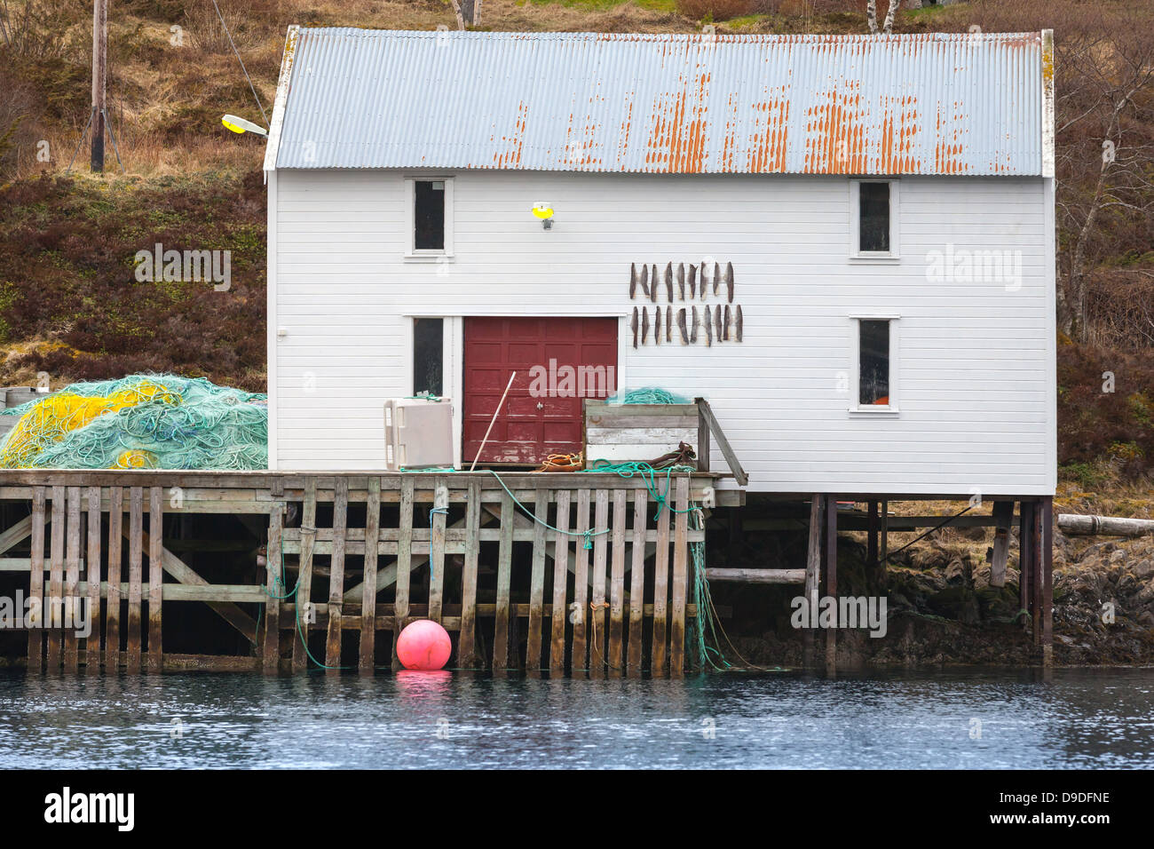Pêche en bois blanc avec grange stockfish sur le mur se dresse sur la côte de la mer de Norvège Banque D'Images