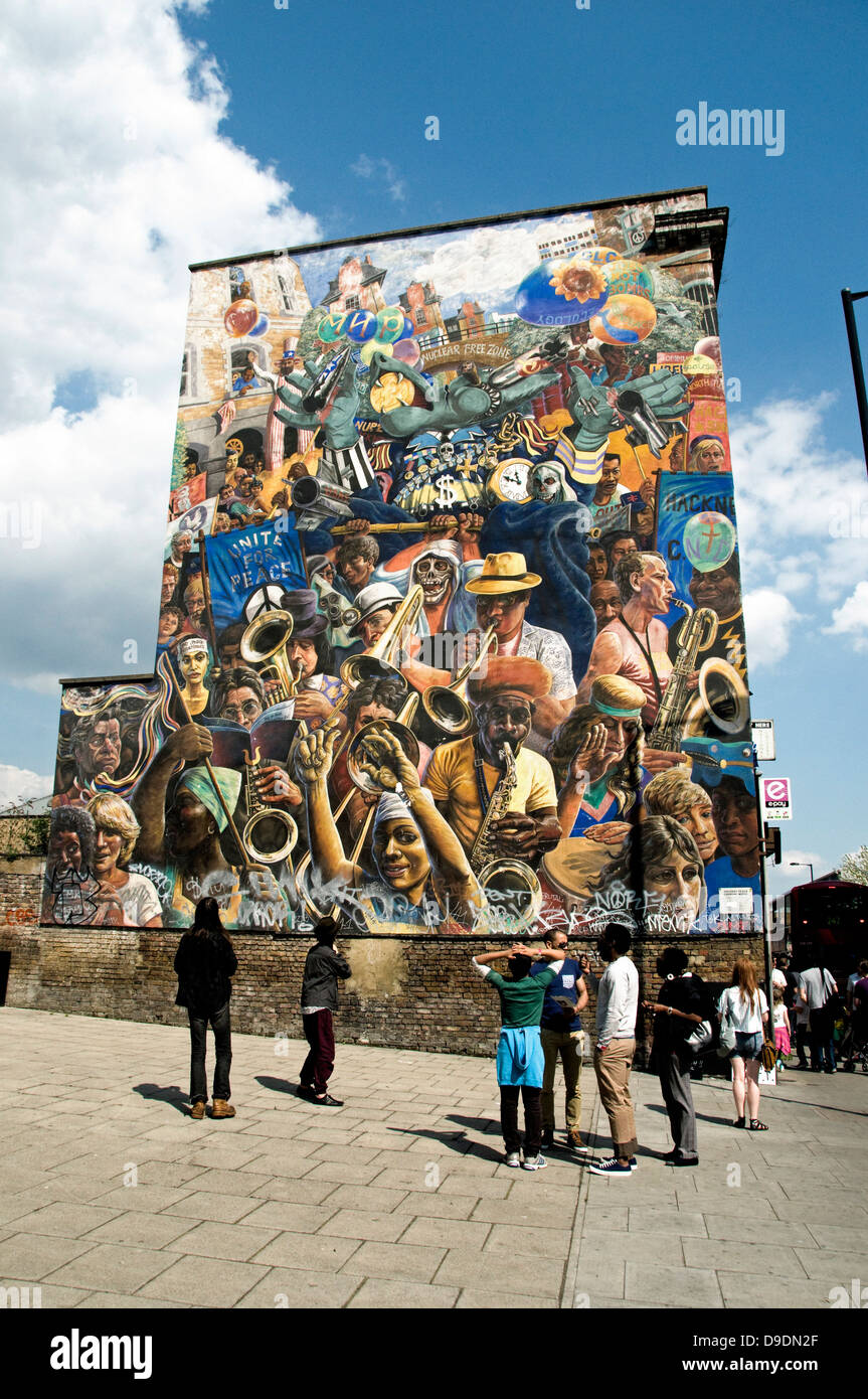 Personnes parlant devant Hackney Peace Carnival mural, Dalston Lane, Dalston, London Borough of Hackney, Angleterre, Royaume-Uni à usage éditorial uniquement Banque D'Images