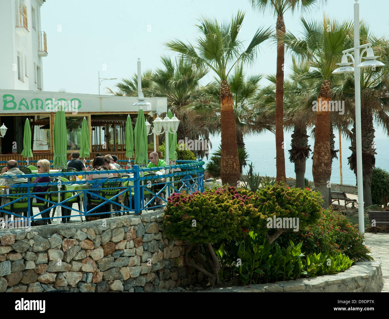 Restaurant espagnol et resort,palmiers,mur,arbustes,les gens de mer de ciel bleu Banque D'Images